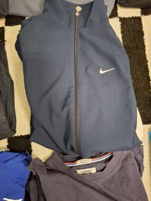 Mörkblå kofta från Nike - Snygg mörkblå kofta från Nike med klassisk logga på bröstet och hel dragkedja framtill. Jackan har en sportig look och är perfekt för dig som gillar streetstyle. Enkel design utan mönster, passar till många outfits.