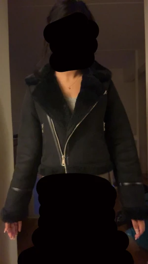 Teddy jacka  - Svart teddyjacka från Pull&Bear i storlek S. Jackan har fluffigt foder, bred krage och flera silvriga dragkedjor framtill. Croppad modell med lång ärm och detaljer i syntetmaterial. Perfekt för dig som gillar en cool och mysig stil.