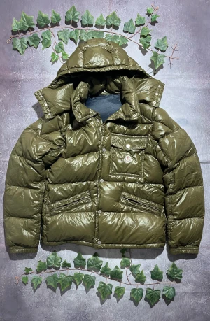Moncler Karak i Olivgrön Storlek L [ÄKTA] - 🎨 Färg: Mörkgrön / Armygrön 📏 Storlek: Large (L) ♻️ Skick: 9/10 – inga synliga skador eller fläckar 🧵 Material: Tjock dunjacka med glansigt nylon-yttertyg ✨ Detaljer: • Klassisk Moncler-dunjacka i rejäl vintermodell • Avtagbar eller fast huva (huvan är fylld och quiltad) • Dragkedja + knappslå framtill • Bröstficka med lock och Moncler-patch • Två snedställda framfickor med dragkedja • Ribbstickade muddar på ärmarna • Mycket varm och isolerande – perfekt för kalla vinterdagar • Stilren och tidlös
