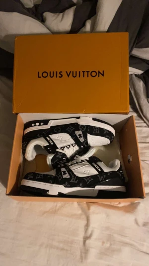 Svartvita sneakers - Sneakers i svart och vitt med klassiskt monogrammönster. Låg modell med snörning, platt sula och rund tå. Snygg kontrast mellan svart och vit, perfekt för dig som gillar exklusiv streetstyle.