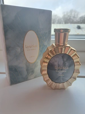Lattafa Victoria Parfym - Lattafa Victoria är en parfym med unik design och lyxig känsla. Perfekt för dig som vill sticka ut och addera en touch av elegans till din stil. Snygg flaska och exklusiv förpackning gör den till ett måste i samlingen.