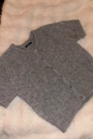 Grå kofta från Gina Tricot - Super fin grå kofta med korta ärmar från Gina. Ser ut som ny🥰säljer då jag inte använder den.