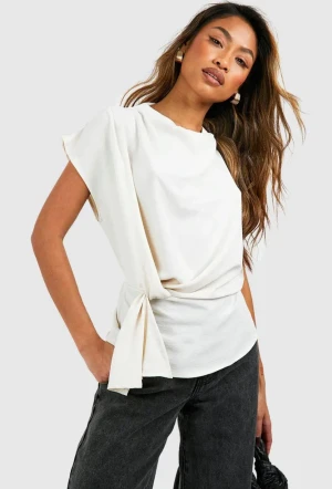 Vit omlott blus med knyt - Säljer en vit blus med omlottdesign och snyggt knyt i midjan. Toppen har korta ärmar och en mjuk, flowy passform som ger en chill och modern vibe. Perfekt att styla med jeans eller kjol för en trendig look. Orginal pris 420kr