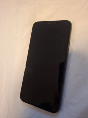 iPhone X - iPhone X med 64GB lagring. Baksidan har sprickor i nedre hörnet och batterihälsan är 76% med varning om försämrat batteri. Skärmen ser hel ut. Perfekt för dig som vill ha en prisvärd iPhone att reparera eller använda som reservdel.
