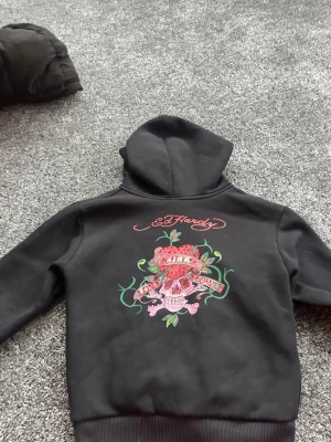 Svart Ed Hardy hoodie - Svart hoodie från Ed Hardy, den är använd några få gånger, och den passar som en xs. Säljs då den är för liten för mig i ärmarna. 
