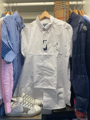 Vit skjorta Polo Ralph Lauren - Vit klassisk skjorta från Polo Ralph Lauren i storlek XXL. Skjortan har button-down krage, broderad logga med polospelare på bröstet. Perfekt till en stilren look till vardagen. Nypris ligger runt 1500, skjortan är aldrig använd och har pristagarna kvar.                                             Skriv vid frågor, priset är inte hugget i sten🤝