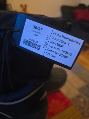 Svarta vinterstövlar strl 36/37 - Svarta vinterstövlar med grov sula och högt skaft. Ovandelen är i slitstark textil med dragsko upptill och kardborreband över vristen. Underdelen är i tålig gummi för att stå emot snö och slask. Perfekta för kalla dagar när du vill hålla fötterna torra och varma.