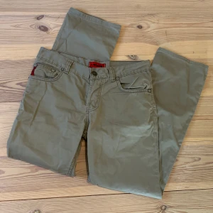 Levi's 505 olivgröna jeans - Säljer ett par olivgröna Levi's 505 jeans med klassisk femficksdesign och raka ben. Byxorna har låg midja och är tillverkade i mjuk bomull. Passar dig som gillar en chill och avslappnad stil. Levi's logga syns på bakfickan.