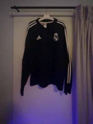 Real Madrid träningströja  - Real Madrid träningströja. Säljer denna mörkblå ish träningströja för att den blivit för liten. Den är i mycket bra skick och i storlek 13-14 y 164 cm.