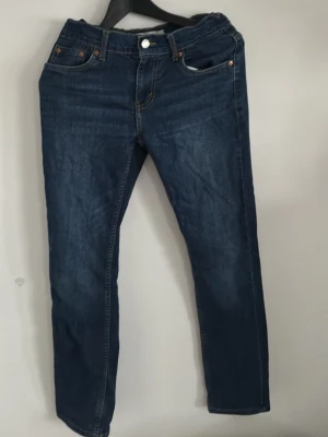 Mörkblå jeans ifrån Lewis, 512 är det. - Snygga mörkblå jeans med klassisk femficksdesign och kontrastsömmar. Jeansen har raka ben och normal passform, perfekta till en avslappnad stil. Tillverkade i slitstarkt denimtyg som ger en cool look.