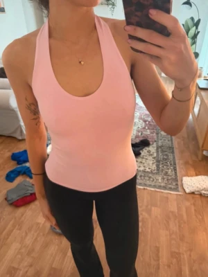 Ljusrosa halterneck linnetopp Gina Tricot - Säljer en ljusrosa halterneck linnetopp från Gina Tricot i storlek XS. Toppen har en djup rundad urringning och är ärmlös med breda axelband som knäpps i nacken. Har sytt den uppe i nacken lite så att den skulle få bättre passform