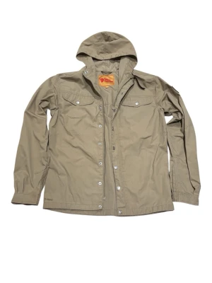 Fjällräven Greenland No. 1 Jacket - Sand/Beige - Size S - A true classic from the Swedish brand Fjällräven. The Greenland No. 1 is inspired by the original jacket from 1968 and is made from durable, wind- and water-resistant G-1000 fabric. This jacket features the iconic leather logo on the sleeve and classic chest pockets.   Condition: Good pre-owned condition. Stains shown in picture 3 and 5