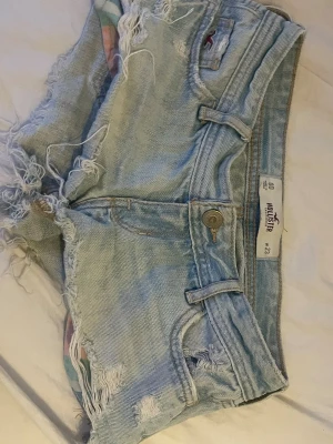 Hollister jeans shorts  - En par jättefina ljus blåa jeans shorts från märket Hollister och är i storlek w 23. De har tyvärr en lite skadad gylf men som säkert går att fixa lätt. Skriv för frågor eller mer info. 