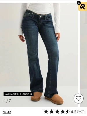 No waist Bootcut jeans  - Mörkblå bootcut jeans från Nelly med låg midja och rå, fransad kant upptill. Jeansen har klassisk femficksdesign, kontrastsömmar och är tillverkade i stretchig denim för en bekväm passform. Perfekta för dig som gillar en avslappnad men trendig look.