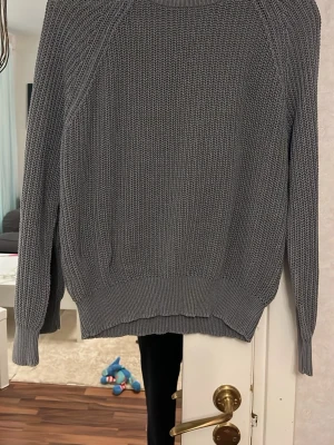 Grå stickad tröja The Black Label - Säljer en grå stickad tröja från Lager157 i storlek M. Tröjan har en chunky struktur, ribbade muddar vid ärmslut och nederkant samt rund hals. Perfekt för kyliga dagar och enkel att matcha med olika outfits. Använt en del men fint skick!