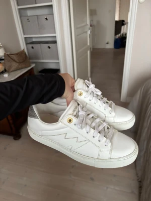 Vita sneakers från Zadig & Voltaire - vita sneakers från Zadig & Voltaire med guldfärgade detaljer och glittrig silver  på hälen. 