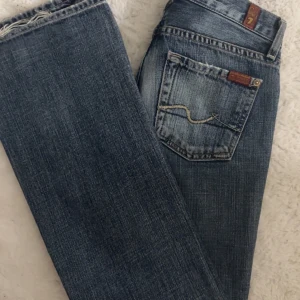 Blå bootcut jeans från 7 For All Mankind - Säljer mina favorit par jeans från 7 for all mankind som tyvärr har blivit för små😔.   •xxs  •lågmidjade, bootcut  •väldigt bra skick   (Skriv jötte gärna privat för mått eller annan information☺️)