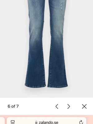 Blå bootcut jeans från LTB, low rise - Säljer ett par blå bootcut jeans från LTB i modellen low rise. Jeansen har slitna detaljer framtill, klassisk femficksdesign och snygg tvättad look. Materialet är jeans med skön stretch och passformen är riktigt chill. 