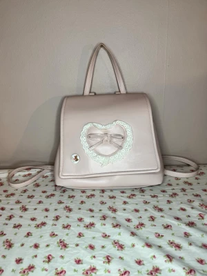 Rosa Lolita Väska - Jättesöt lolita ryggsäck med justerbara axelremmar💗Väskan har en pin som desvärre lämnar ett märke om man tar bort den, det är upp till köparen om du väljer att behålla den eller intemen säljer den extra billigt pga det☺️Förutom det är väskan nästan i nyskick💗