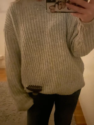 Grå stickad tröja från lager 157 - Mysig grå stickad tröja från lager 157 i storlek S. Tröjan har en loose passform och är perfekt för kyliga dagar. Grovstickad struktur och långa ärmar ger en avslappnad vibe. Passar dig som gillar oversized och comfy stil!