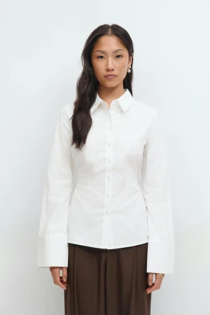 Vit skjorta med vida manschetter - Klassisk vit skjorta i bomull med lång ärm och extra vida manschetter. Skjortan har knappar framtill och en rak passform som ger en clean och stilren look. Perfekt för dig som gillar minimalistisk stil och vill ha något som sticker ut med detaljerna vid ärmsluten.