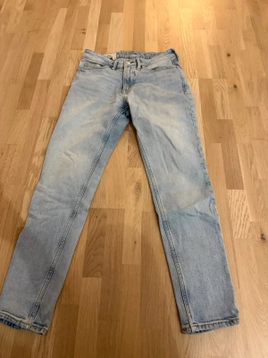 Ljusblå jeans  - Säljer ett par ljusblå jeans från H&M med tapered regular fit. Klassisk femficksmodell och snygg tvättad look. Perfekta till sneakers eller boots och riktigt sköna att bära hela dagen. Midjehöjd och raka ben som smalnar av nedtill.