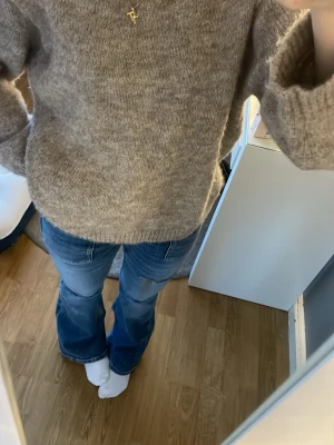 Beige stickad tröja från Gina Tricot - Mysig beige stickad tröja från Gina Tricot i storlek XS. Tröjan har en enkel, rak passform med långa ärmar och rund hals. Perfekt för lager på lager under kyliga dagar och superenkel att matcha med jeans eller kjol. 