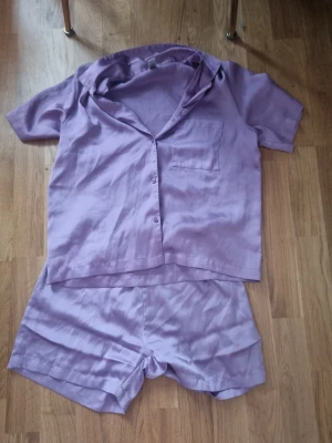 Ljuslila pyjamas set - Säljer ett par ljuslila shorts från i mjuk och glansig återvunnen polyester. Shortsen har elastisk midja och en relaxed fit som känns riktigt chill. 