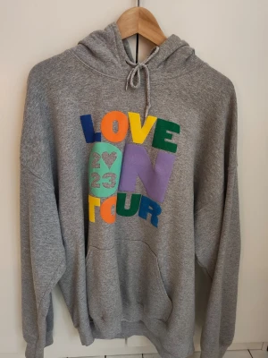 Harry Styles Love On Tour hoodie  - Hoodie från Love On Tour - Harry Styles. Köpt på hans hemsida strax efter turnen haft sitt slut sommaren 2023 - Storlek L. Några små sprickor i det turkosa på trycket (se sista bilden) det var så redan när jag fick hem den, annars bra skick! 