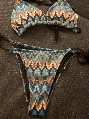 Missoni liknande bikini - Säljer en skitsnygg bikini med missoni mönster, perfekt till sommaren! Ej använd, vet tyvärr inte märket då jag fick av min syster eftersom den inte passade henne!