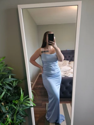 Ljusblå satinklänning - Nelly - Klänning från Nelly Glansigt vävt material Stretchigt foder på insidan Rynkningar på sidorna  Smala axelband Maxilängd - ny med prislapp kvar. ordinarie pris 899:-, rea nu 449:- men slutsåld. #nelly #fancysatindress #maxiklänning