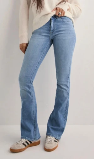 Bootcut ljusblå jeans - Snygga ljusblå bootcut jeans med klassisk femficksdesign. Jeansen har en rak passform över låren och blir vidare nedtill, vilket ger en cool siluett. Tillverkade i mjukt denimtyg som sitter bekvämt hela dagen.