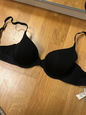 Svart Calvin Klein bh 65D - Svart bh från Calvin Klein, knappt använd, storlek 65d men passar mig som vanligtvis har 70b!