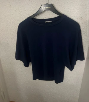 Mörkblå kortärmad topp - En enkel och stilren mörkblå topp med rund hals och korta ärmar. Perfekt för dig som gillar en clean look och vill ha något som funkar till jeans eller kjol. Materialet känns mjukt och skönt mot huden.