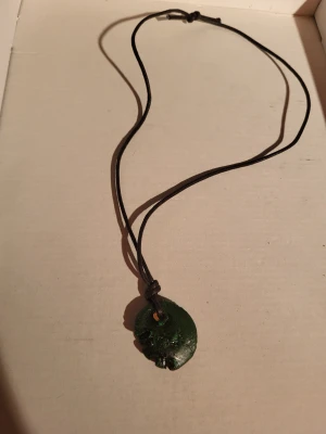 Vintage clay necklace 1990s - Corded necklace with a clay pendant painted green with black accents. The paint has unfortunately chipped a bit. 