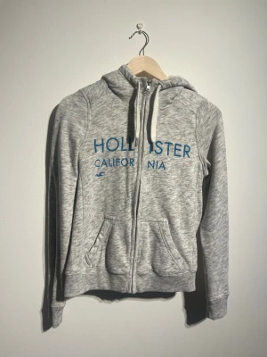 Hollister Fodrad Hoodie - Hej! Säljer nu denna väldigt snygga och varma Hollister Hoodien. Storlek XS   Färg: Grå & Vit Skick: Mycket gott – endast använd vid enstaka tillfällen  Skickas spårbart eller hämtas upp efter överenskommelse. Vid intresse – hör gärna av dig.  Skriv vid frågor eller ifall du vill ha fler bilder:) 