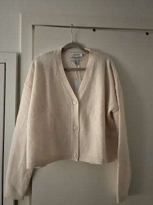 Beige kofta från &other stories  - Mysig beige kofta från & other stories med v-ringning och tre knappar framtill. Lappen är på och gjord av 100% ull😊 Passar XS och S