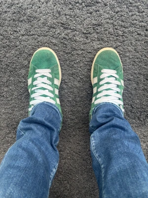 Adidas Campus  - Snygga adidas campus i storlek 46 - men är lite små i storleken så passar 45 oxå. Jag har 45 och den passar bra pp mig. Perfekta skor till vardagligt bruk och riktigt sköna med mjukt material intill. Använda i ett halvår ungefär. Grymma dojor!   🎨 Färg: Gröna med vita detaljer  ✅ Skick: 8/10 - liten defekt vid hälen (se bild 3) annars i riktigt bra skick.  🧵 Modell: Adidas Campus  ✨Otroligt sköna & snygga    ‼️ Skickas samma dag eller dagen efter köpet genomförs ‼️
