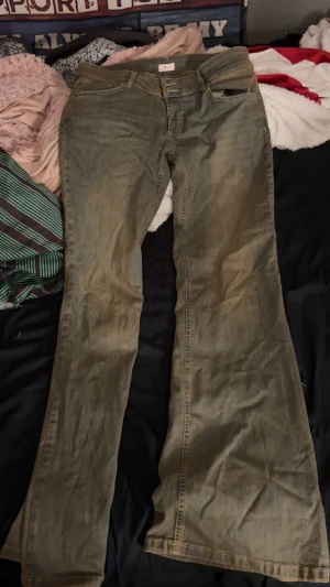 Bootcut jeans från Nelly, grå - Bootcut jeans från Nelly i en grå tvättad nyans. Klassisk femficksmodell med knapp och dragkedja framtill, samt detaljerade bakfickor med lock och knapp. Jeansen har normal passform och är tillverkade i jeansmaterial.