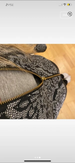 Svart och grå jacka med mönster - Säljer en svart och grå jacka med detaljerat mönster och guldfärgad dragkedja framtill. Jackan har lång ärm och är tillverkad i ett material som är både mjukt och bekvämt. Perfekt för dig som gillar coola mönster och vill ha något unikt i garderoben.