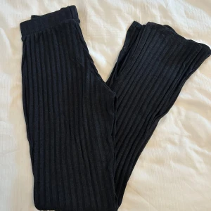 Svarta ribbade byxor med slits från Gina Tricot  - Snygga svarta byxor med ribbad struktur och ben med slits från Gina Tricot i storlek XXS. Perfekta för en avslappnad stil. Byxorna är i bra skick då de är använda några gånger. 