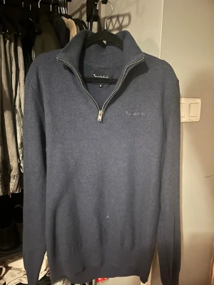 Blå halvzip tröja från Bondelid - Mörkblå långärmad tröja från Bondelid med halv dragkedja och hög krage. Tröjan är i mjukt stickat material och har diskret broderad logga på bröstet. Perfekt för lager på lager under kyliga dagar.