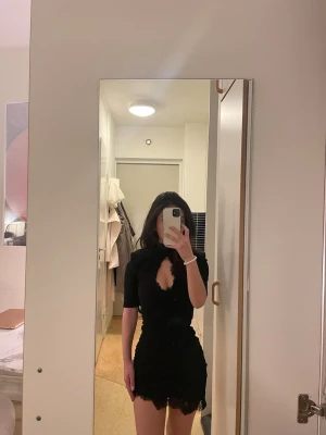 Svart miniklänning  - Ny mini Svart festklänning med spetsdetaljer och fin passform, strl 32 (xxs). Från noughts and kisses, originalpris över 1000 med tull. Endast prövad. 