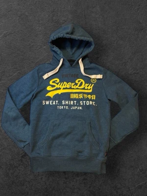 Superdry Hoodie - Blå Superdry Hoodie - Storlek: S - Pris: 499 kr - Tröjan är i fräsch och har används sparsamt - Först till Kvarn!