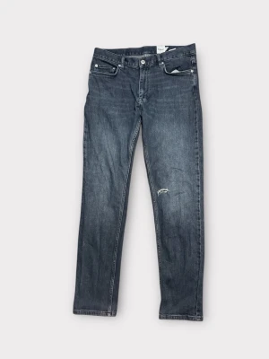 Mörkblå jeans från Dobber W33 L32 - Jeans från Dobber, en liten sliten detalj på ena benet. Jeansen har raka ben och normal passform, tillverkade i tåligt denimtyg. Ytterbenslängd 106cm, 41cm, lårvidd 24cm, benöppning 16,5cm. Om ni har några funderingar är det bara att skicka en pling!