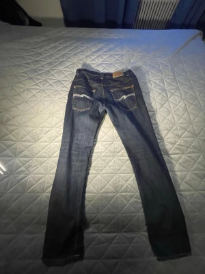 Mörkblå jeans från Nudie Jeans - Säljer ett par mörkblå jeans från Nudie Jeans dom sitter mer som 31/32 än 33/32 priset kan diskuteras hör av er om mer bilder. 