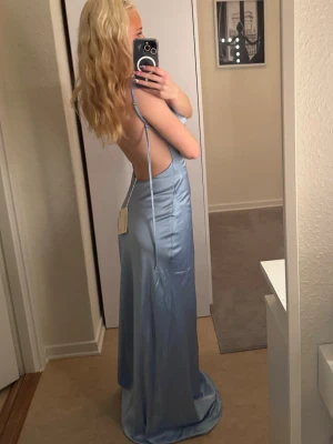 Bal klänning - Jag säljer denna ljusblå satin klänning som jag skulle ha till min bal 2025 men jag ändrade mig och ville ha en gul balklänning så denna kom aldrig till användning. Den är väldigt fin och den passar allt från xs-m då den är lös i passformen, men den är 36. (jag hade spänt den på sista bilden) den har ett dubbel foder av satin som gör att den inte är lika tunn och genomskinlig🩵pris kan ändras vid snabb affär