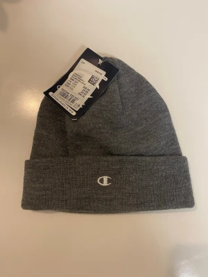 Beaniemössa - Säljer en jättefin beaniemössa från märket Champion. Den är helt ny och oanvänd med prislappen fortfarande på. Skriv vid frågor och funderingar.