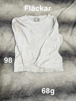 Vit långärmad t-shirt  - En enkel vit långärmad t-shirt från Lindex. Rund halsringning med liten spetskant som detalj. Perfekt basplagg till garderoben och lätt att matcha med allt.🌸 Fläckar. Storlek 98