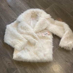 Ny oanvänd Vit pälsjacka från Nelly XS - Helt ny och oanvänd fluffig och supermjuk vit pälsjacka från Nelly i storlek XS. 